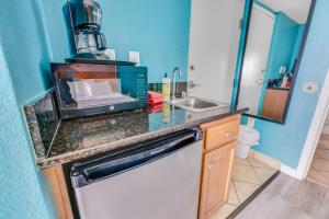 a kitchen with a sink and a microwave on a counter at Oceanfront,Heated Pools,Boardwalk, Location,Views! in Myrtle Beach +54 photos