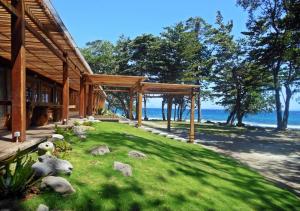 a house with a grassy yard next to the ocean at The Pade Dive Resort in Sabang