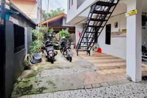 two motorcycles parked next to a building with a staircase at Villa Citra Syariah RedPartner in Kalibata 1