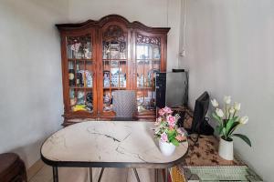 a room with a table and a wooden china cabinet at Villa Citra Syariah RedPartner in Kalibata 1