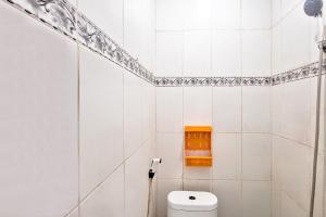 a bathroom with a toilet and a shelf on the wall at Villa Citra Syariah RedPartner in Kalibata 1
