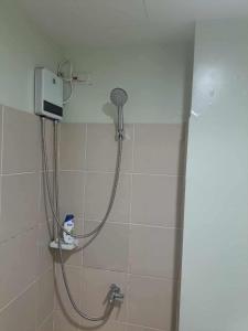 a shower with a shower head in a bathroom at Brenthill Condo Ruby unit in Baguio +7 photos