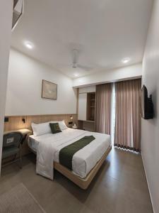 a bedroom with a bed and a desk and a television at The Zen Retreat in Kozhikode
