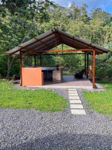 a picnic shelter with a bench in a park at Casa Colibrí in Bijagua