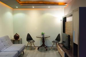 a living room with a couch and a tv and a table at Hotel Gilfer Puebla Centro Histórico in Puebla