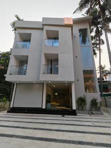a large white building with palm trees in front of it at The Zen Retreat in Kozhikode +10 photos