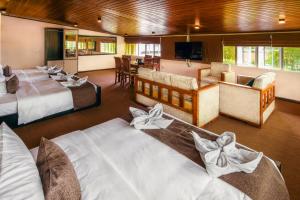 a hotel room with two beds and a living room at La Cottage in Nuwara Eliya +31 photos