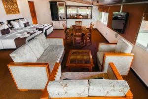 a living room with couches and a dining room at La Cottage in Nuwara Eliya