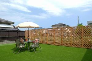 a patio with a table and chairs and an umbrella at Wave House 99 Beachside - Self Check-In Only in Kujukuri