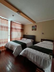 a bedroom with two beds and a window at Casa del Virrey Hospedaje in Jauja +56 photos