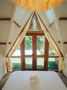 a bed in a room with a large window at Vibes Villas Siargao in General Luna