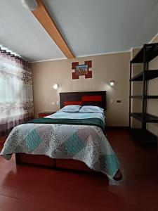 a bedroom with a large bed with a cross on the wall at Casa del Virrey Hospedaje in Jauja