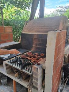 a person is cooking food on a grill at Casa Campestre Kostal Azul in Tocaima