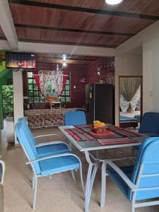 a dining room with a table and blue chairs at Casa Campestre Kostal Azul in Tocaima