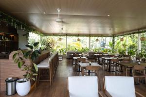 a restaurant with tables and chairs and plants at TIKA Lombok in Kuta Lombok