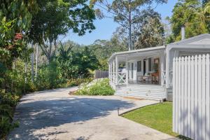 a white tiny house with a driveway at Firefly Cottage in Mount Tamborine