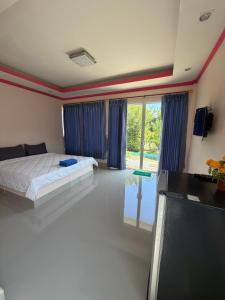 a bedroom with a bed and a large window at Ying Fah Resort in Ban Na Sok