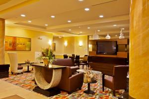 a lobby with a waiting room with chairs and a tv at Holiday Inn Express-International Drive by IHG in Orlando