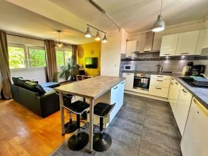 a kitchen with a table and a couch in a room at Duplex with Jacuzzi and parking Close to Disney in Lognes