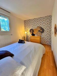 a bedroom with a large white bed and a window at Duplex with Jacuzzi and parking Close to Disney in Lognes