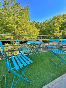 three blue chairs and a table on the grass at Duplex with Jacuzzi and parking Close to Disney in Lognes