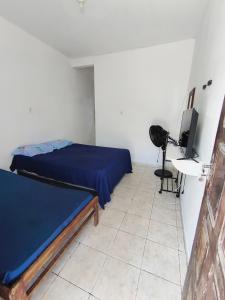 a bedroom with a bed and a desk and a television at Quarto na Atalaia in Aracaju