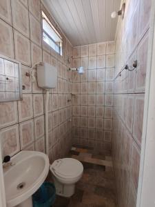 a bathroom with a toilet and a sink at Quarto na Atalaia in Aracaju