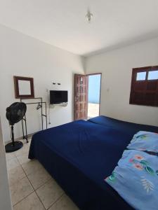 a bedroom with a blue bed and a television at Quarto na Atalaia in Aracaju