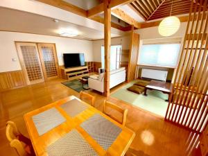 a living room with a table and a television at Luxury Villa N and N in Aomori