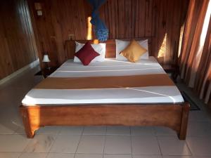 a large wooden bed with two pillows on it at Wood cabin in Kandy