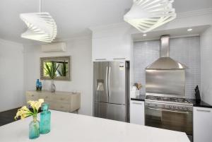 a kitchen with a stainless steel refrigerator and a stove at Bliss On Pearl Key in Gold Coast