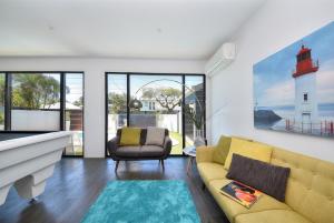 a living room with a yellow couch and a lighthouse at Bliss On Pearl Key in Gold Coast