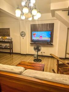a living room with a couch and a flat screen tv at casita de flocerfida in Boac