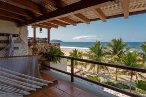 a balcony with a hammock overlooking the beach at Stunning, Oceanfront Casa de Olas in Ixtapa-Zihuatanejo International