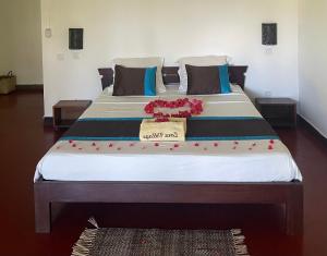 a large bed with red flowers on top of it at Zara Village in Nosy Be