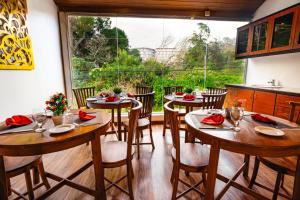 a dining room with four tables and a large window at La Cottage in Nuwara Eliya