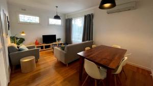 a living room with a table and chairs and a television at Driftwood in Venus Bay +13 photos