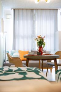 a living room with a table with a vase of flowers on it at 森 BREEZE furano MORI in Furano