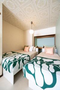 two beds in a room with a coffered ceiling at 森 BREEZE furano MORI in Furano