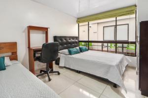 a hospital room with two beds and a desk at Casa Magi in Bogotá