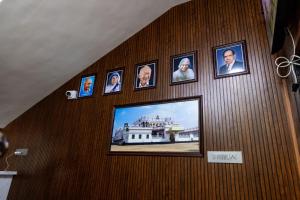 a television hanging on a wall with pictures on it at SKS Residensy in Kāraikkudi