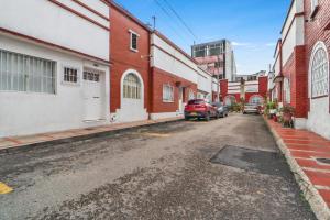 an alley with cars parked on the side of a street at Casa Magi in Bogotá