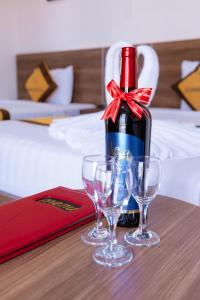 a bottle of wine and two wine glasses on a table at Sonne Hotel Quang Binh in Dong Hoi