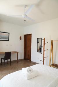 a white bedroom with a bed and a desk at Buena Vista in El Paredón Buena Vista