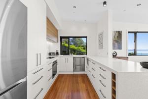 a kitchen with white cabinets and a large window at Vista al Mar in Pohara
