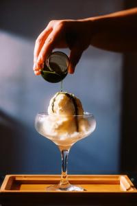 a person is pouring a green olive into a dessert at Casa Pichay in Vigan