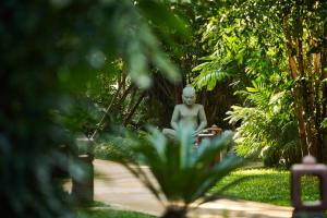 a statue of a woman sitting in a garden at TUI BLUE Angkor Grace Wellness Resort in Siem Reap