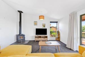 a living room with a couch and a tv at Kotare Heights in Pohara