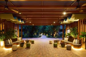 a lobby with couches and tables and trees at TUI BLUE Angkor Grace Wellness Resort in Siem Reap