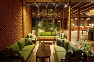 a living room with green couches and a table at TUI BLUE Angkor Grace Wellness Resort in Siem Reap +79 photos